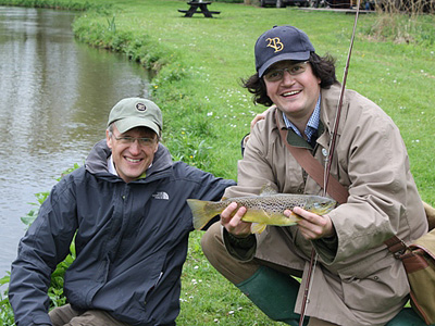 David Mitchell (r) catches his first trout under guidance from the chairman of the APPGA, Charles Wilson MP 