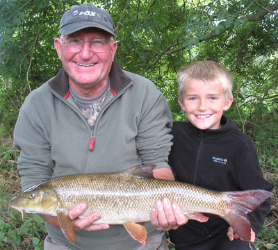 Granddad and grandson with a first barbel.